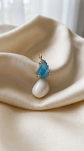 shell pendent with feather blue stone